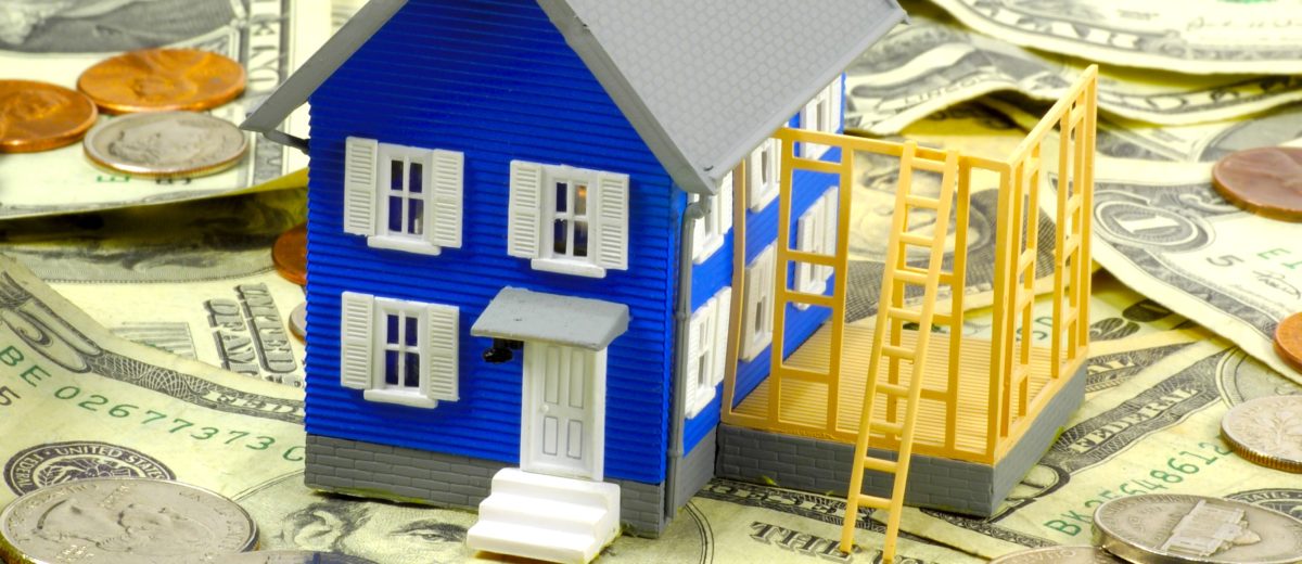 Miniature House sitting on Money depicting there is Equity in the house