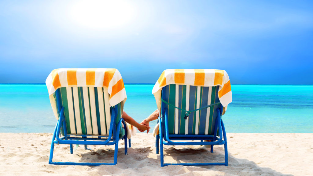 Two beach chairs facing ocean depiction vacation on beach