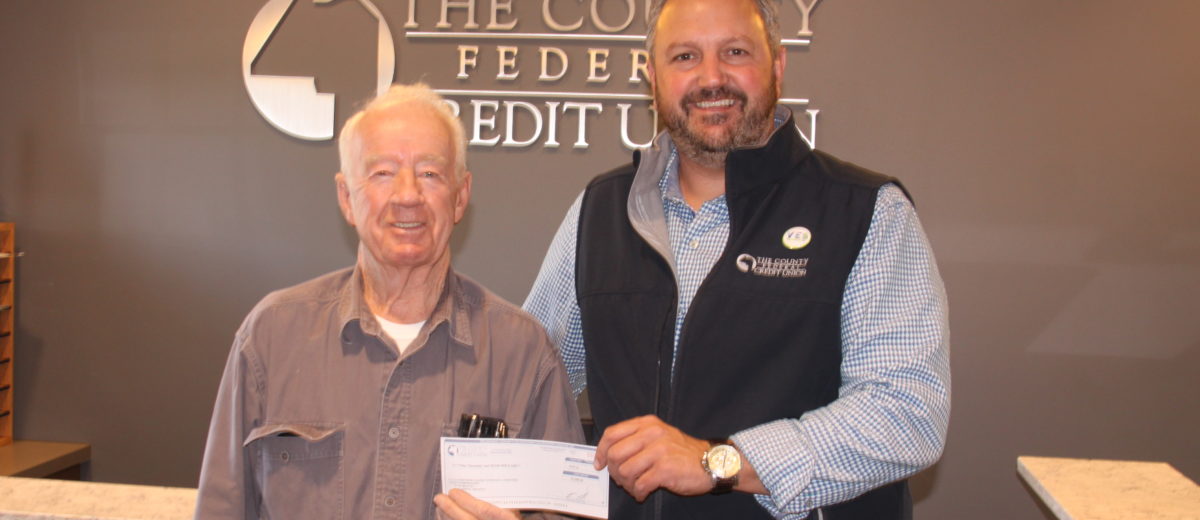 Photo of Harry Hafford and Ryan Ellsworth passing a check for the new veterans monument at the Veterans Cemetary in Caribou
