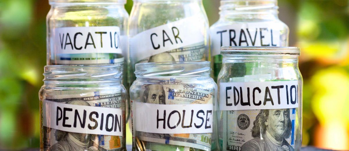 Money jars with money in each with tags that read vacation, car, travel, pension, house and education.
