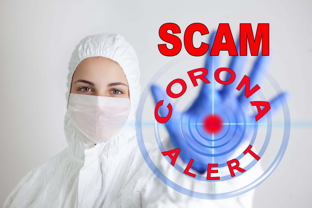 Health care person holding up hand with words Scam corona alert